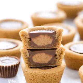 Gluten Free Reese’s Peanut Butter Cookie Cups are a chocolate + peanut butter lovers’ dream cookie! They’re peanut butter cookies baked in mini muffin tins then stuffed with peanut butter cups. Simply amazing! SUPER EASY cookie recipe to make too! Recipe from @whattheforkblog | whattheforkfoodblog.com | gluten free cookie recipes | easy dessert recipes | homemade peanut butter cookies | how to make peanut butter cookies | #glutenfree #chocolate #peanutbutter #cookies #dessert #easyrecipes