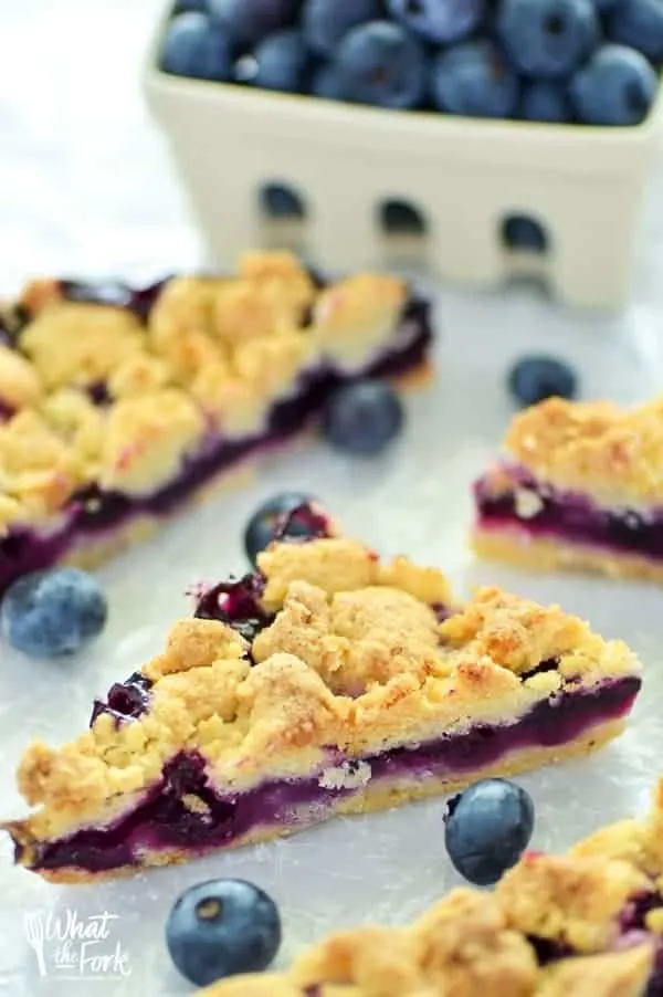 These Gluten Free Blueberry Crumb Bars are made with fresh blueberries and are a really delicious dessert or snack. The crumb is nice and crisp and the lemon zest makes these bright and fresh! Recipe from @whattheforkblog | whattheforkfoodblog.com | gluten free dessert recipes | easy gluten free desserts | summer recipes | summer desserts | recipes for fresh blueberries | fruit desserts