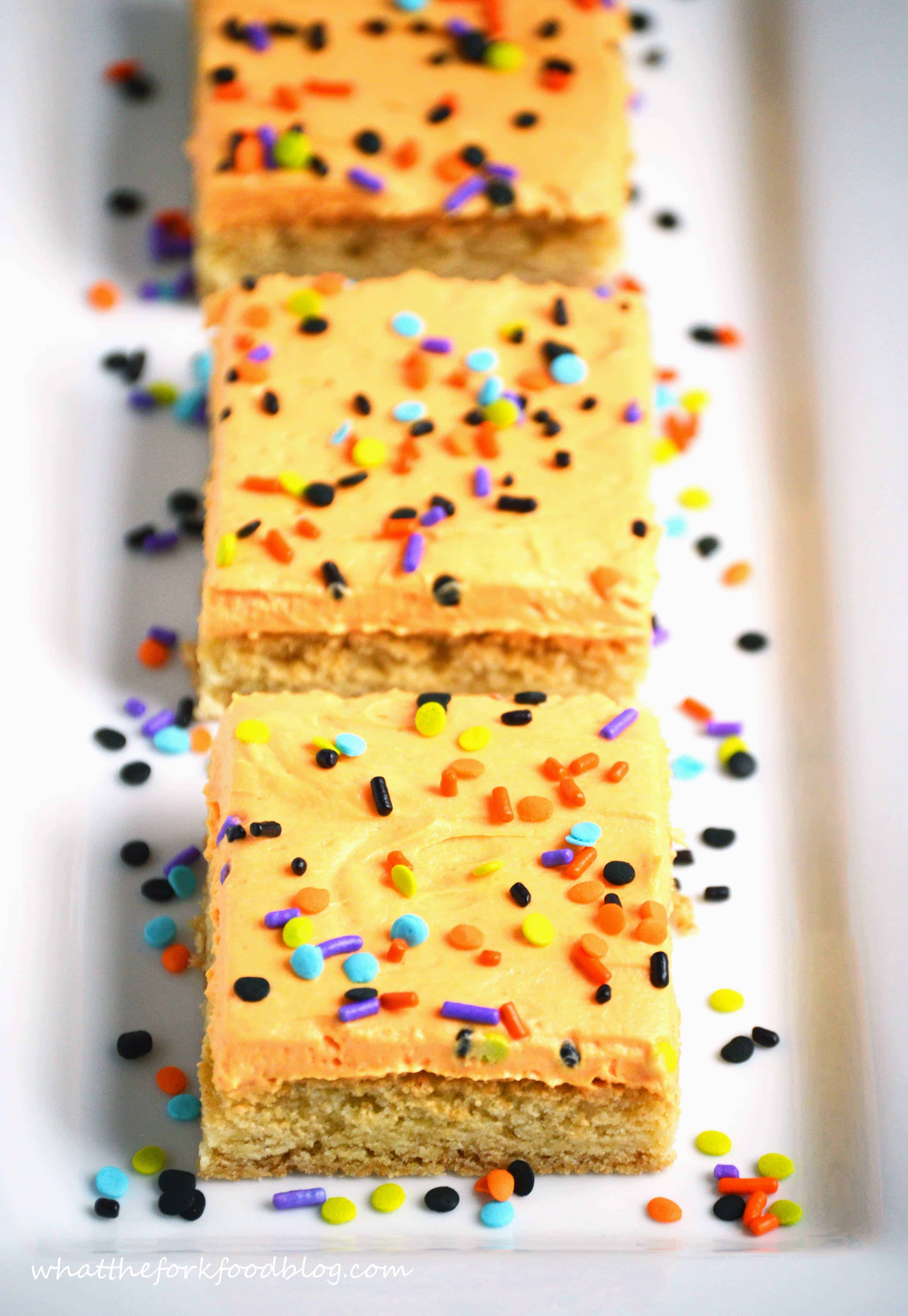 Frosted Sugar Cookie Bars with Halloween Sprinkles cut and placed on a white rectangular platter