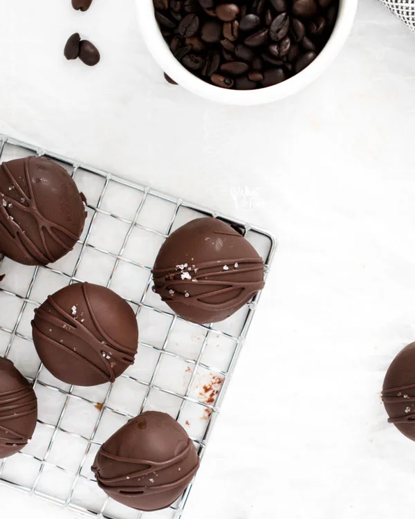 overhead shot of chocolate dipped chocolate truffles on a small wire rack