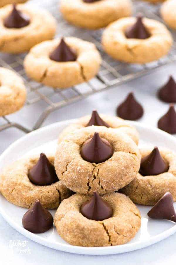 These gluten free peanut butter blossoms are a staple dessert during the Christmas season and are everyone’s favorite cookie! They’re easy to make and perfect for gifting! Recipe from @whattheforkblog | whattheforkfoodblog.com | gluten free cookie recipes | homemade food gifts | peanut butter cookies | easy gluten free dessert recipes | homemade cookies | #peanutbutter #chocolate #baking #cookierecipes #christmascookies #glutenfree #glutenfreecookies #glutenfreebaking #glutenfreerecipes