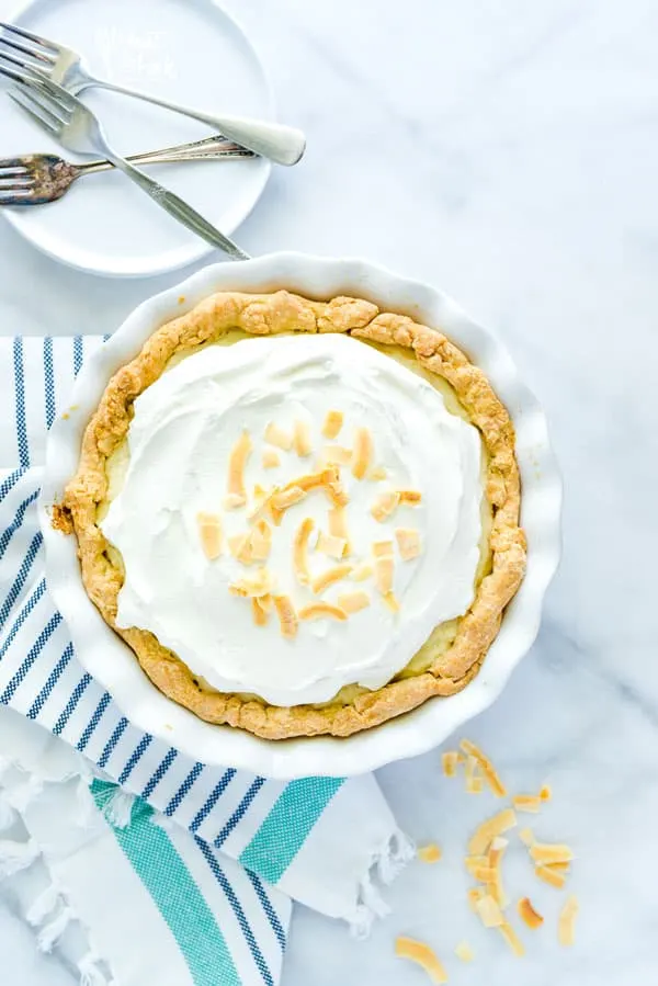 Coconut Cream Pie is a true dessert comfort food! Flaky pie crust filled with creamy coconut custard, layered with sweet fresh whipped cream and topped with toasted coconut. It’s a DREAM! Make it with a gluten free pie crust or a regular pie crust, your choice! This easy pie recipe is great for any holiday or get together. Easy dessert recipe from @whattheforkblog - visit whattheforkfoodblog.com for more! #glutenfree #pie #coconut #dessert #easydessert #recipe #dessertrecipes #coconutrecipes