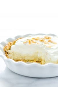 Gluten Free Coconut Cream Pie in a white pie dish with a slice cut out
