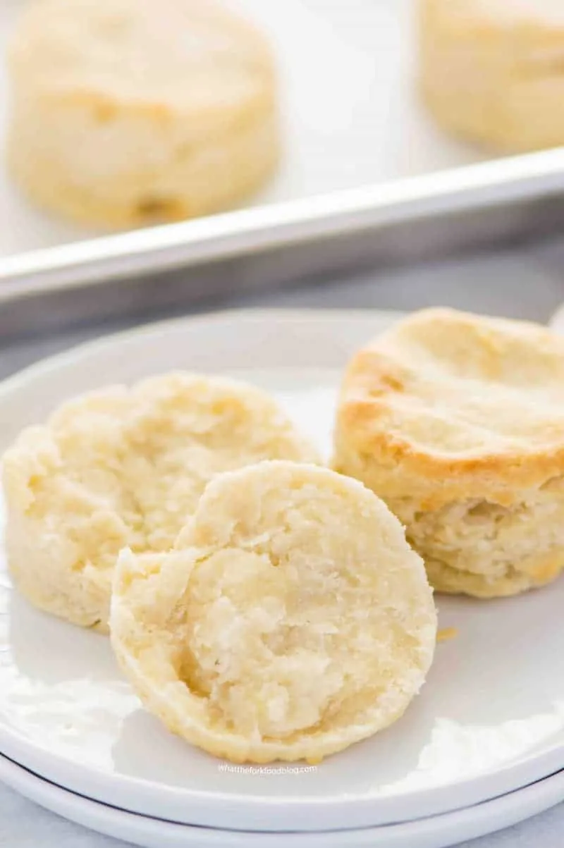 Sliced gluten free biscuit with butter on it.