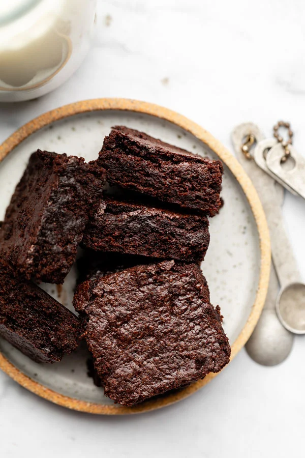 overhead shot of sliced fudgy gluten free brownies on a white plate