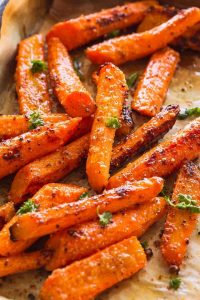 roasted carrots on a sheet pan garnished with chopped fresh parsley