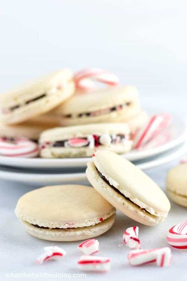 Gorgeous Macarons flavored for Christmas! These peppermint macarons are made with a basic macaron shell and filled with peppermint chocolate ganache and crushed candy canes - they’re heavenly! Gluten free and dairy free macaron recipe from @whattheforkblog | whattheforkfoodblog.com | Sponsored | how to make macarons | easy macaron recipe | french macarons | macaroon | french macaron filling | french macaron flavors | macaron recipe flavors