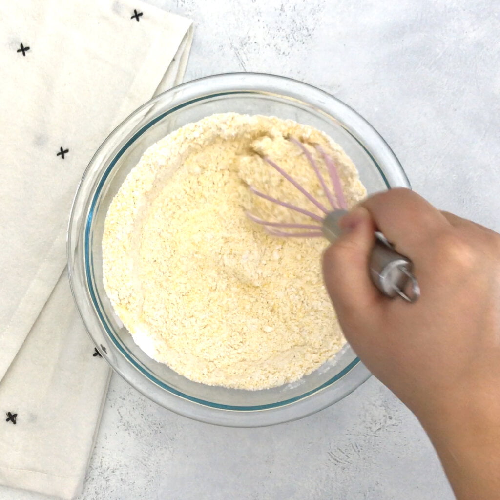 In a large bowl, whisk together the gluten free flour, xanthan gum, cornmeal, sugar, baking powder, and salt. Set aside.

