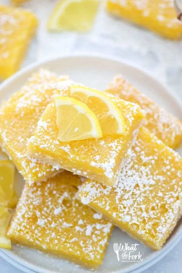 Easy and delicious gluten free lemon squares. They're not too tangy and just sweet enough! Perfect for Easter, bridal showers, baby showers, or any dessert table. Recipe from @whattheforkblog | whattheforkfoodblog.com | Sponsored | lemon bars | gluten free desserts | easy gluten free recipes | Spring desserts | lemon custard with shortbread crust | best recipes | gluten free baking