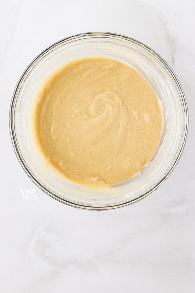 gluten free vanilla cupcake batter mixed together in a large clear glass bowl