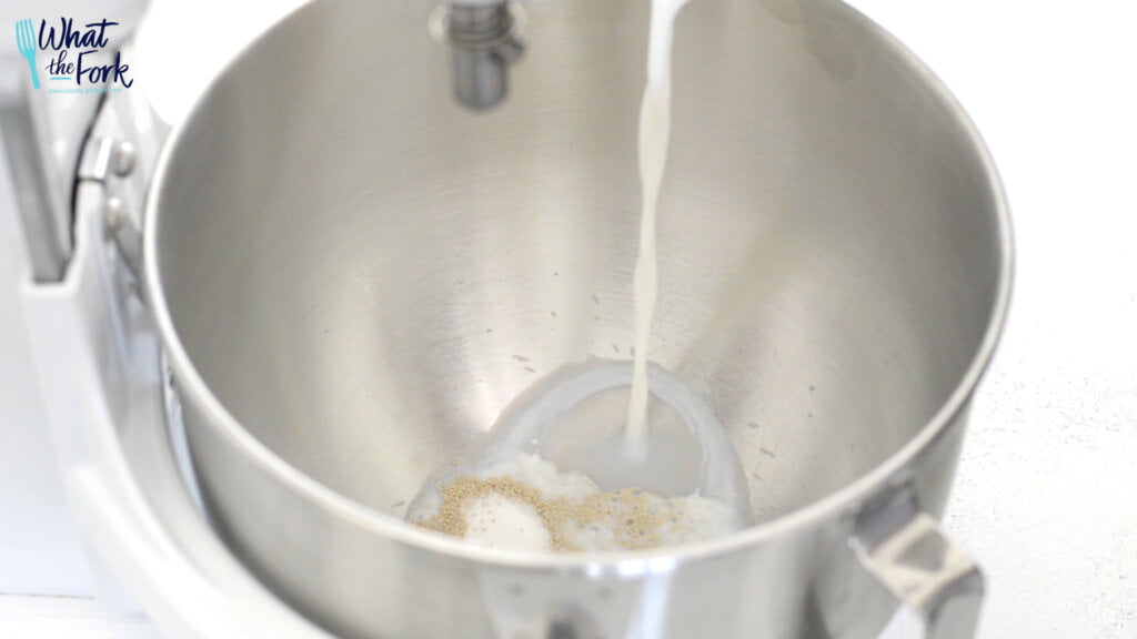 Add yeast and granulated sugar to bowl of stand mixer then slowly pour in milk.