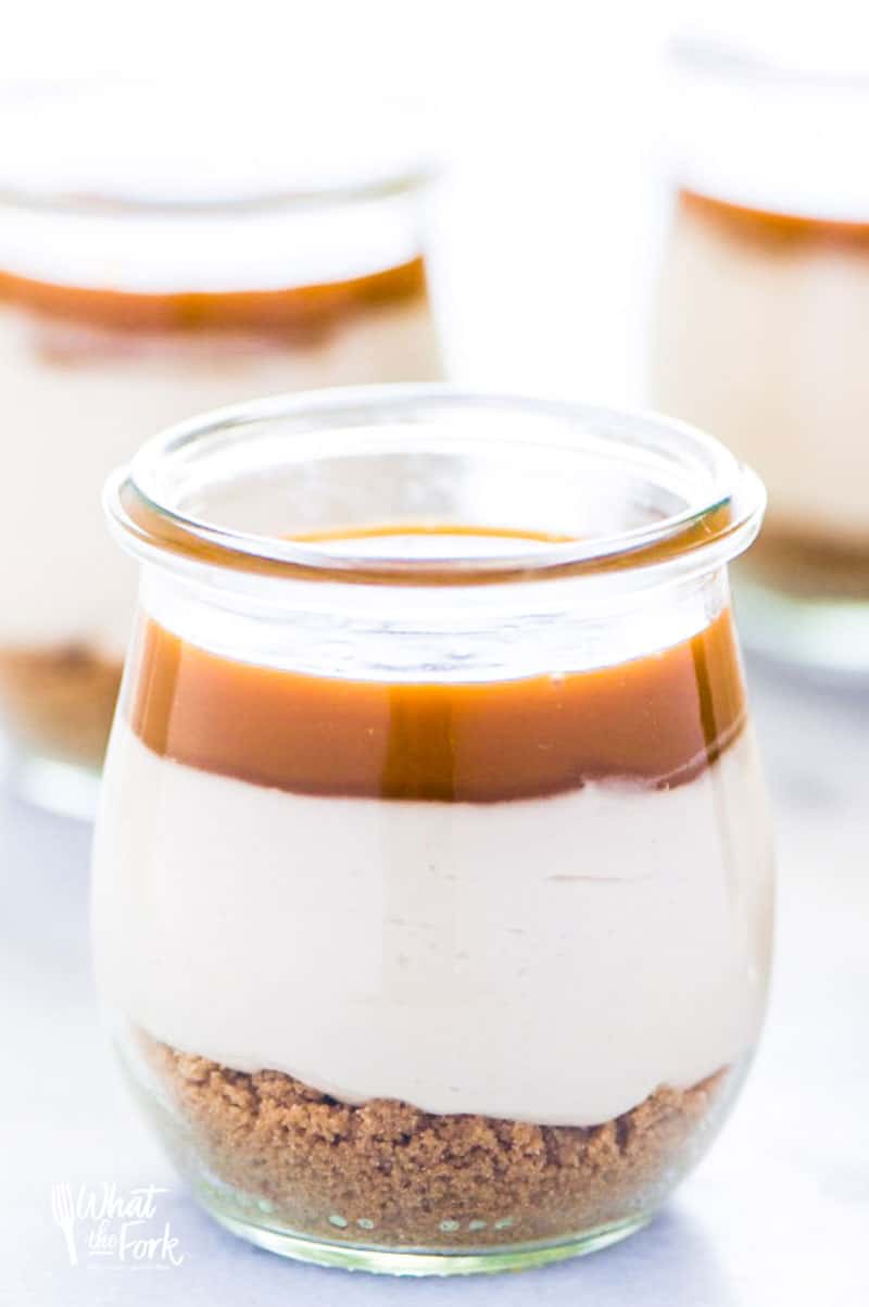 These Gluten Free Individual No-Bake Salted Caramel Cheesecakes make a great dessert for a smaller dinner party or family dessert. They’re really easy to make and are full of salted caramel flavor! Top them with whipped cream and Heath Bars or chocolate covered pretzels! @whattheforkfoodblog | whattheforkfoodblog.com | easy gluten free desserts | no-bake cheesecake | no-bake dessert recipes #nobake #glutenfree #glutenfreerecipes #nobakecheesecake #easyrecipes #saltedcaramel #dessert #cheesecake