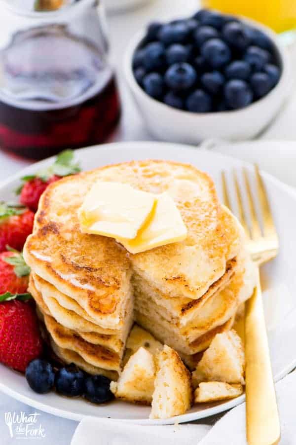 Hero shot of fluffy GF pancake recipe with strawberries on the side.