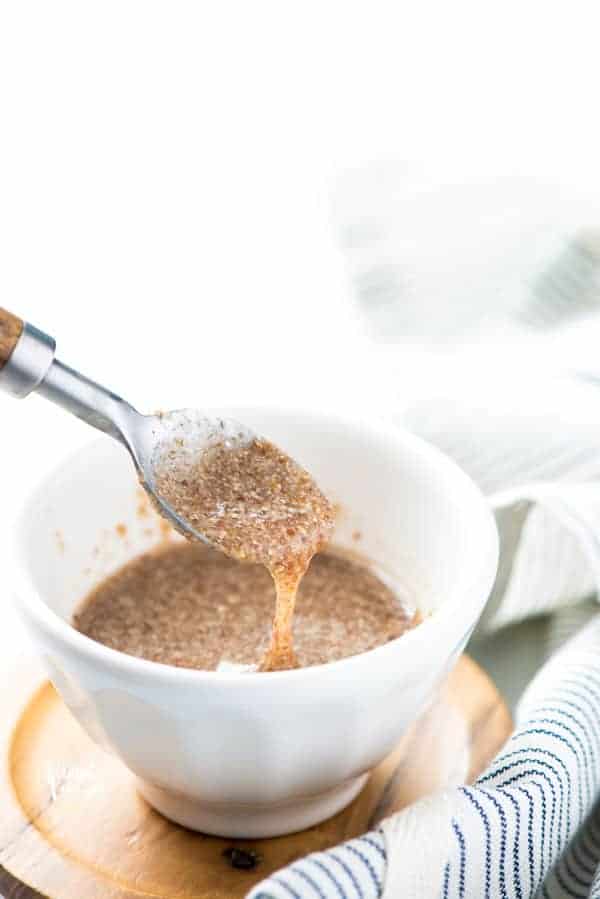 flax egg in a white bowl being scooped to show consistency