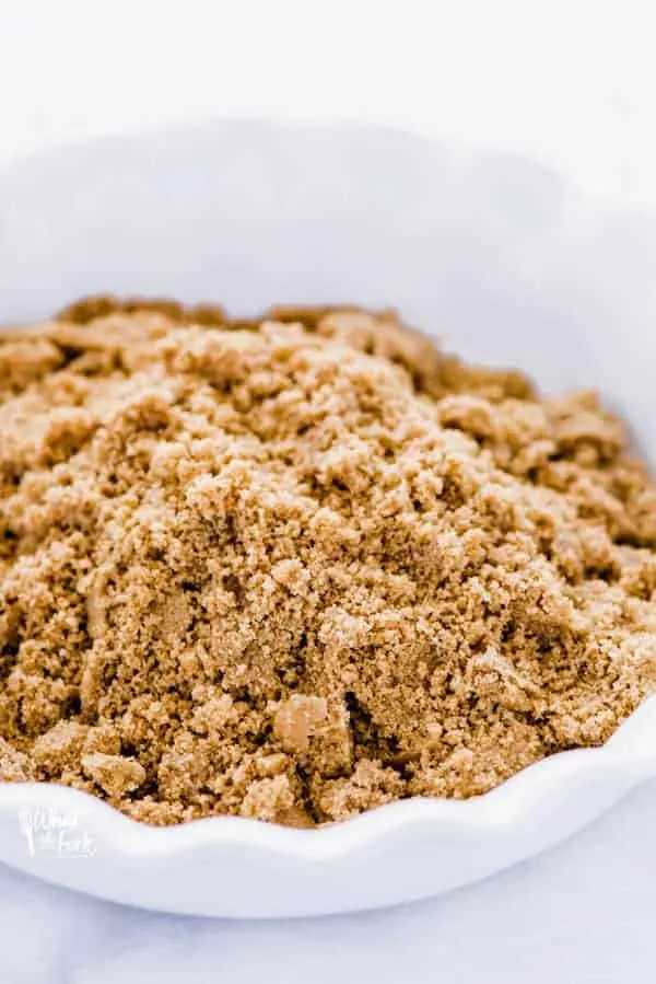 Graham cracker crust crumbs in a white pie dish to show how to make a gluten free graham cracker crust