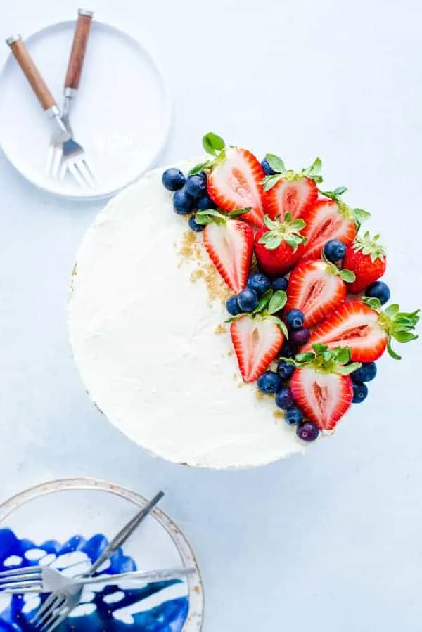 A whole, easy no bake cheesecake topped with fresh strawberries and blueberries