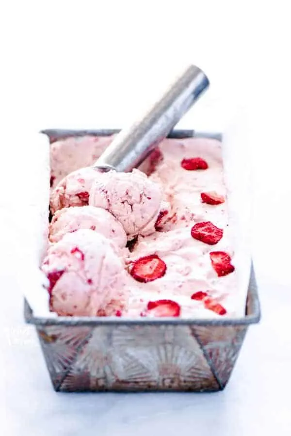 No-churn strawberry ice cream recipe being scooped with a silver ice cream scoop