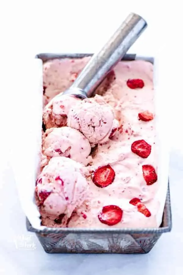 No-churn strawberry ice cream recipe being scooped with a silver ice cream scoop