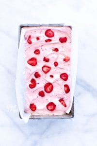 Finished no-churn strawberry ice cream recipe frozen in a rectangle pan