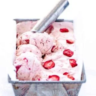 No-churn strawberry ice cream recipe being scooped with a silver ice cream scoop