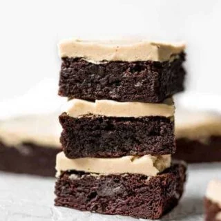 Stack of three gluten free brownies with peanut butter frosting.