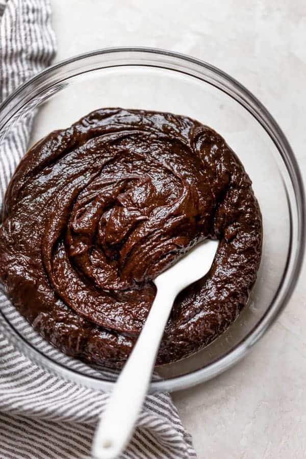 gluten free brownie batter in a glass bowl with a white spatula