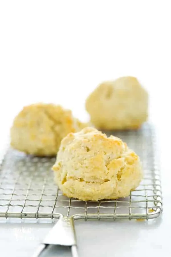 three gluten free drop biscuits on a wire rack