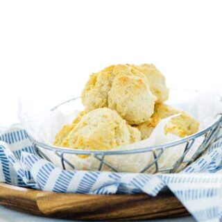 Gluten Free Drop Biscuits in a wire bread basket with a blue towel
