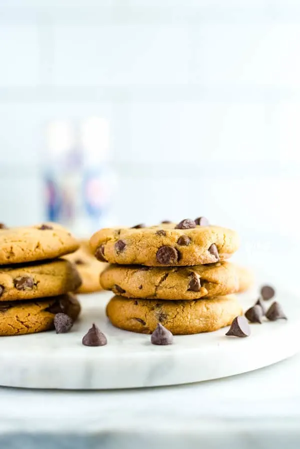 Stack of gluten free peanut butter chocolate chip cookies on a marble slab garnished with chocolate chips