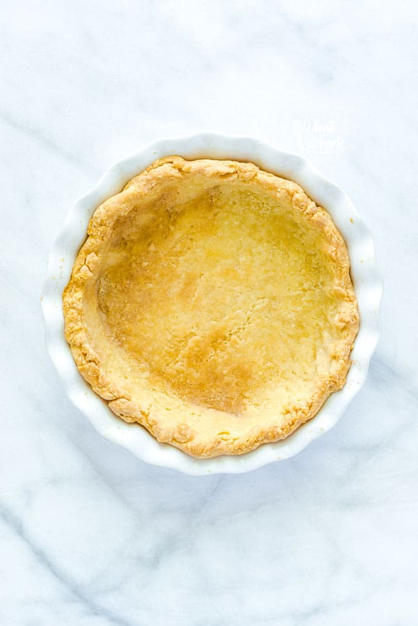 A blind baked pie crust in a white pie plate