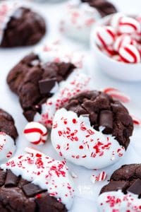 These Triple Chocolate Peppermint Cookies are the ultimate Christmas cookie! They’re bakery style chocolate cookies with chunks of chocolate inside. Then they’re dipped in white chocolate and sprinkled with candy cane pieces. They are one of my favorite cookies ever! Easy gluten free cookie recipe from @whattheforkblog - visit whattheforkfoodblog.com for more! #cookies #Christmas #chocolate #peppermint #christmascookies #glutenfree #glutenfreecookies #baking #recipes #glutenfreerecipes