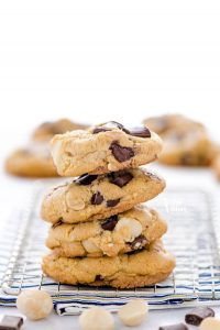 A stack of gluten free Chocolate Macadamia Nut Cookies on a small wire rack.