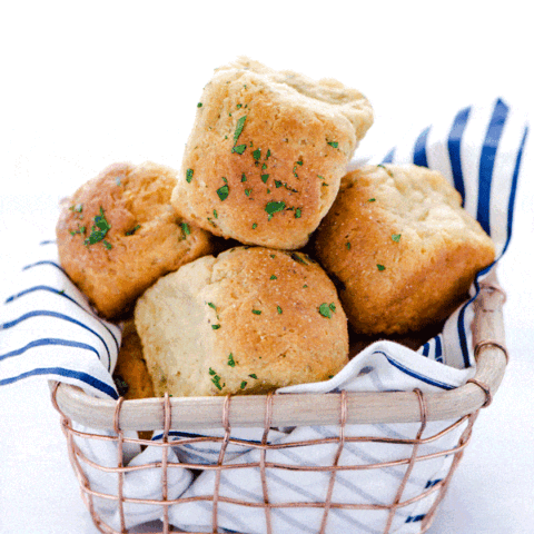 Gluten Free Dinner Rolls with Garlic and Herbs in a wire basket with a blue and white striped napkin