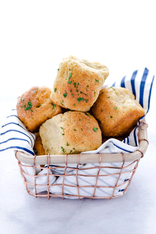 Gluten Free Dinner Rolls with Garlic and Herbs in a wire basket with a blue and white striped napkin