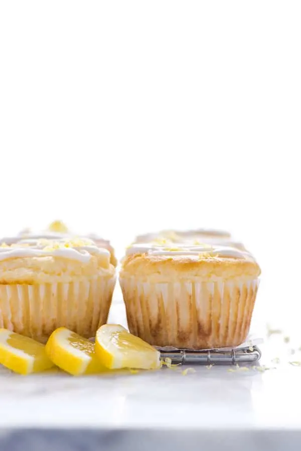 Gluten Free Lemon Ricotta Muffins on a wire rack garnished with lemon slices