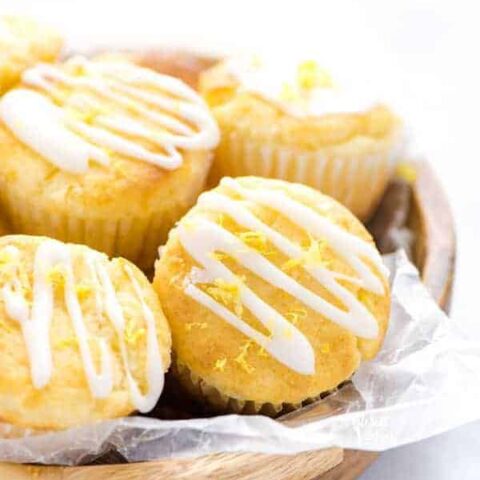 Closeup of Gluten Free Lemon Ricotta Muffins in a wood bowl lined with wax paper