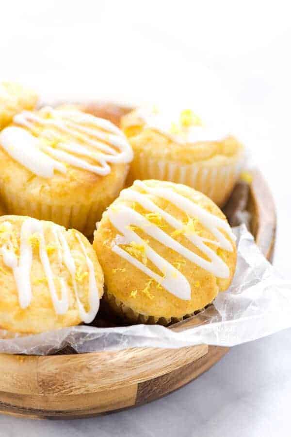 Closeup of Gluten Free Lemon Ricotta Muffins in a wood bowl lined with wax paper