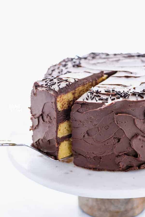 A slice of gluten free yellow cake being removed from the cake