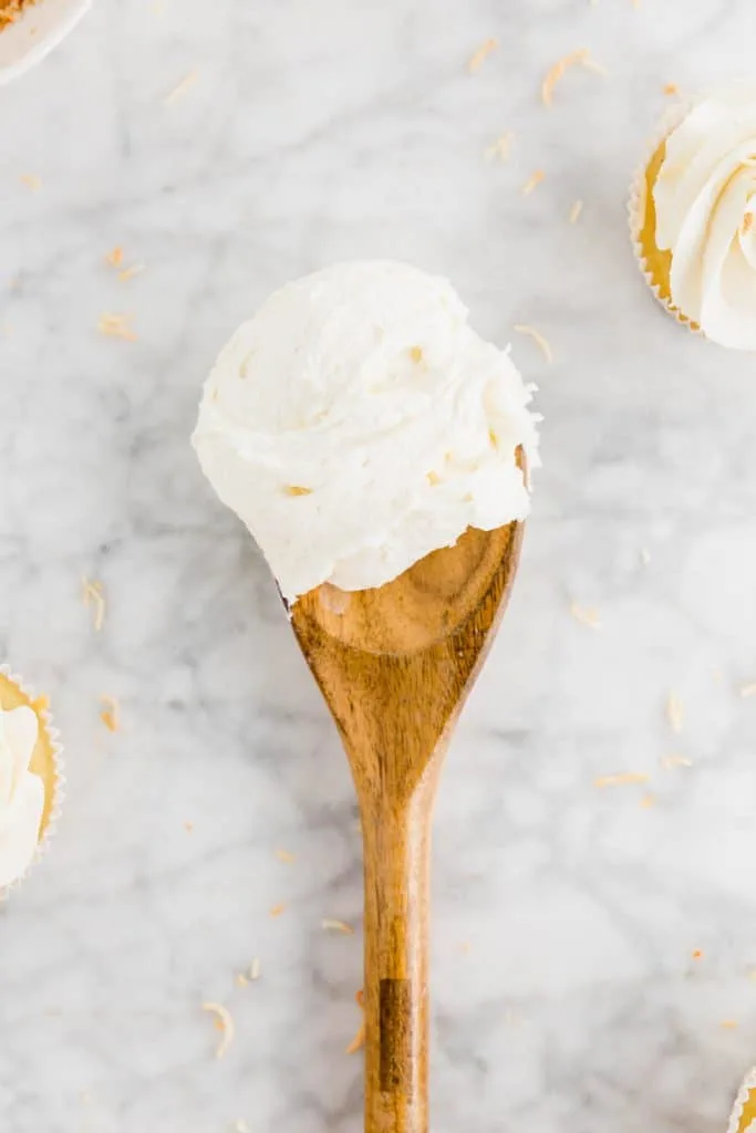 This simple Coconut Frosting recipe tastes anything but basic. It's got tons of tropical coconut flavor! It pairs great with coconut cake and chocolate desserts like brownies or cupcakes. Top it with some toasted coconut for an easy garnish. Recipe from @whattheforkblog - visit whattheforkfoodblog.com for more easy dessert recipes! #buttercream #frosting #dessert #coconut