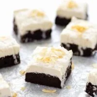 Slices of Gluten Free Brownies with Coconut frosting on wax paper ready to serve.