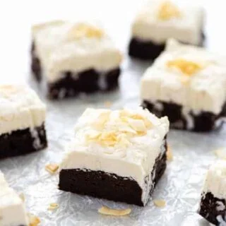 Slices of Gluten Free Brownies with Coconut frosting on wax paper ready to serve.
