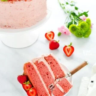 Made from scratch Gluten Free Strawberry Cake made with fresh strawberries, no extracts or artificial flavors! This cake is moist and VERY full of fresh strawberry flavor. Finish it off with homemade strawberry cream cheese frosting and garnish with fresh strawberries, a dusting of freeze-dried strawberry powder, and edible flowers for a gorgeous presentation. This makes a 3-layer 8-inch cake or halve the recipe for 2 6-inch layers. #strawberrycake #strawberryrecipes #cake #glutenfree #dessert