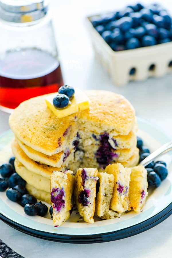 Easy homemade fluffy Gluten Free Blueberry Pancakes are full of fresh blueberries bursting with flavor. Great for breakfast, brunch, or dinner. Plus they freeze well so make a double batch to save some for later! This recipe makes the best blueberry pancakes! Gluten Free breakfast recipe from @whattheforkblog - visit whattheforkfoodblog.com for easy gluten free recipes! #glutenfree #pancakes #breakfast #easyrecipe #blueberry #blueberrypancakes
