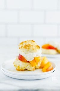 Gluten Free Peach Shortcake on a white plate garnished with fresh peaches