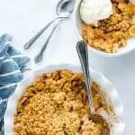 Gluten Free Apple Crisp features warm, spiced apples and a crisp oatmeal cookie-like topping. It’s the perfect dessert to make in the fall! Follow this recipe and you’ll make the best apple crisp recipe every time that’s full of flavor and contrasting textures. It’s an old fashioned recipe with a modern twist. Serve it with vanilla ice cream or homemade whipped cream! Visit whattheforkfoodblog.com for more gluten free desserts. #applecrisp #bestapplecrisp #glutenfree #fallbaking #applerecipes
