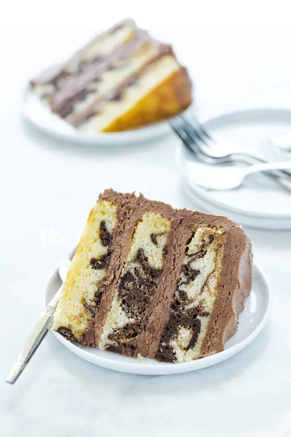 This is the best recipe for homemade gluten free marble cake! It's a moist, 3 layer vanilla cake swirled with chocolate cake batter. It's the perfect combination of chocolate and vanilla, perfect for indecisive dessert eaters! This is a stunning cake for any occasion - birthday cake, wedding cake, anniversary cake, baby shower, or bridal shower! Gluten Free Cake recipe from @whattheforkblog -visit whattheforkfoodblog.com for more gluten free desserts #glutenfree #cake #marblecake #glutenfreecake