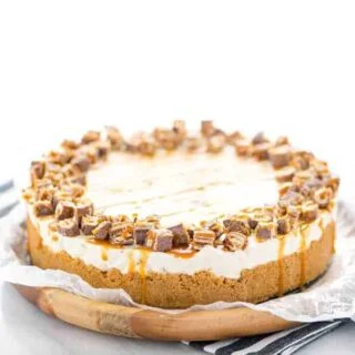Gluten Free Chocolix No Bake Cheesecake recipe on a round wood board lined with wax paper.