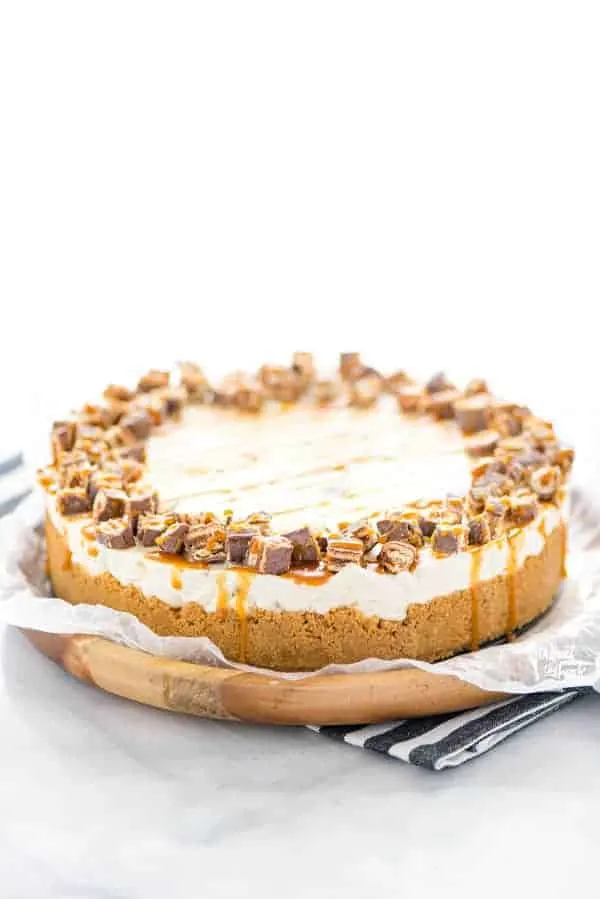 Gluten Free Chocolix No Bake Cheesecake recipe on a round wood board lined with wax paper