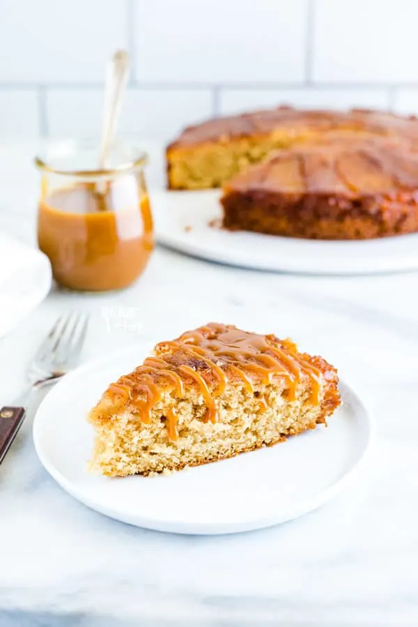 a slice of gluten free apple upside down cake on a white plate