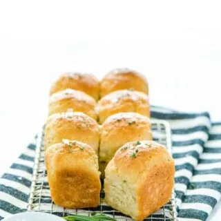 Gluten Free Rosemary Rolls on a wire rack and striped towel